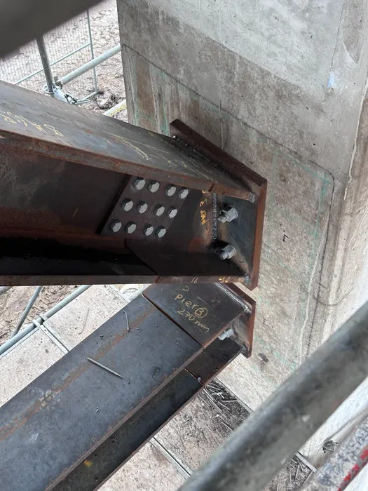 Steel beam connection alongside a concrete structure